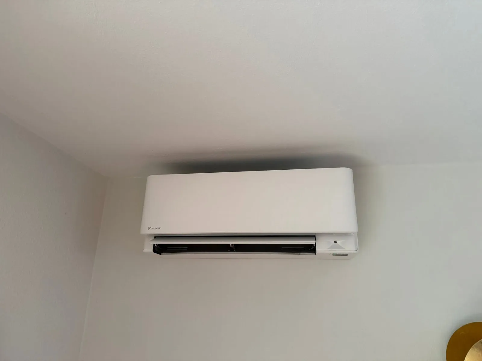 Wit airco-binnendeel strak gemonteerd op een egale wand
