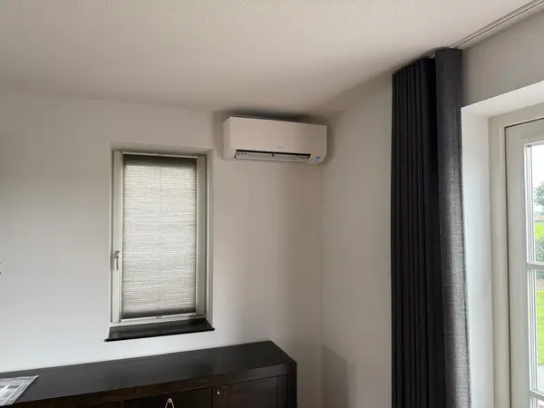 Wit Daikin airco-binnendeel netjes gemonteerd in een woonkamer