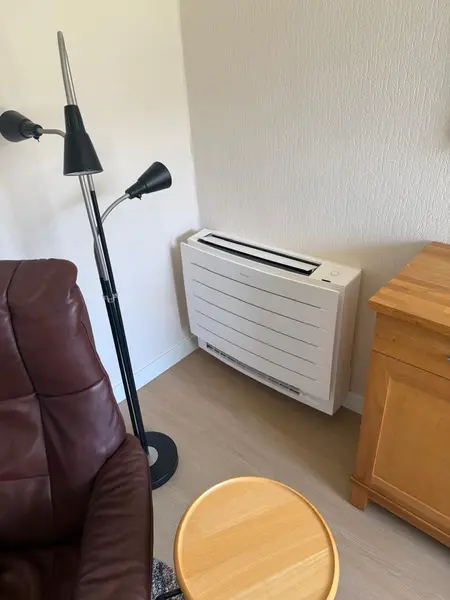 Daikin-vloermodel airco in een woonkamer, ideaal om ook mee te verwarmen