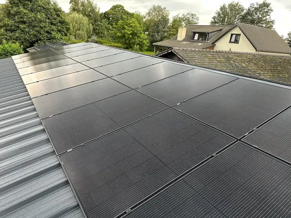 Zonnepanelen op een metalen dak, met de woning op de achtergrond