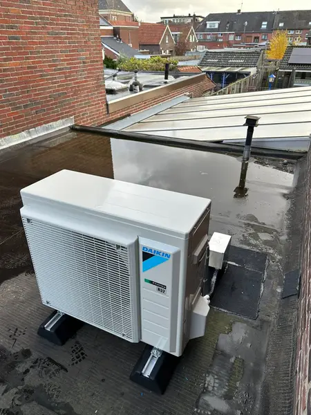 Buitenunit op een plat dak met dakrand