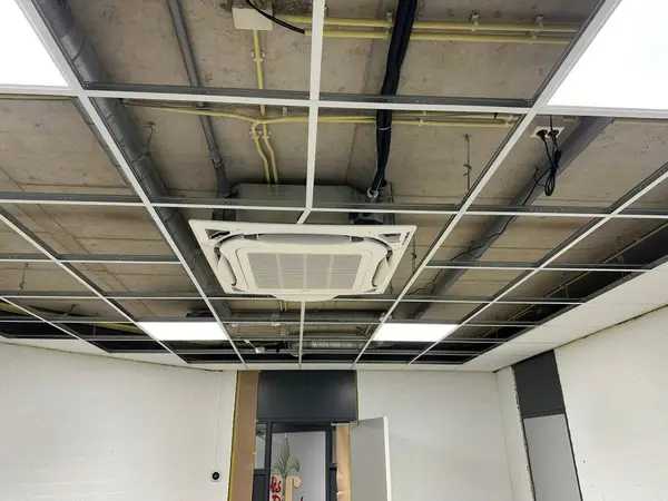 Cassette-unit in een donker systeemplafond van een bedrijfsruimte