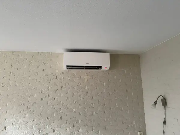 Wit airco-binnendeel op een gestructureerde wand