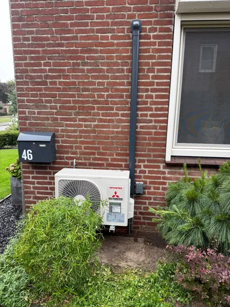 Buitenunit in een border naast de voordeur