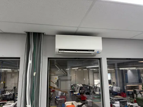 Wit airco-binnendeel in een werkplaats